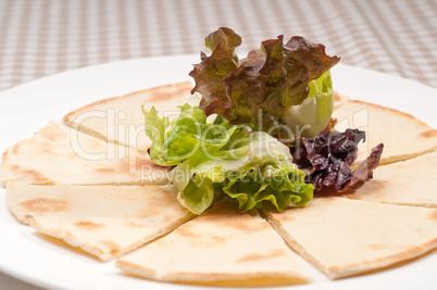 garlic pita bread pizza with salad on top