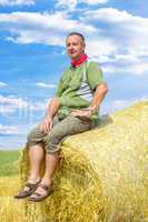 Farmer sitting on straw bales