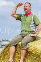 Farmer sitting on straw bales