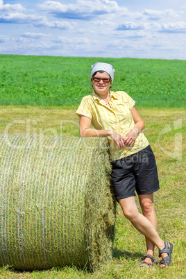 Farmer standing next to hay