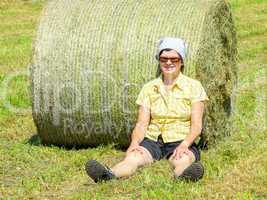 Farmer sitting in front of hay bales
