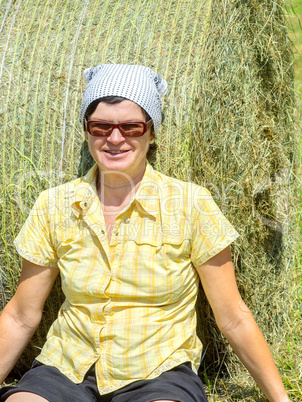 Farmer sitting in front of hay bales