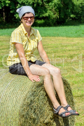 Peasant woman sitting on the hay bale