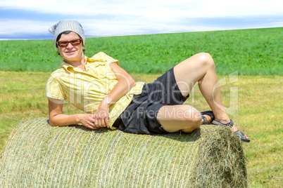 Peasant woman is lying on the hay bales