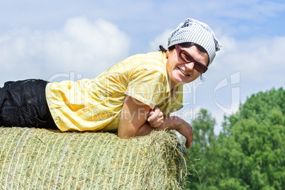 Peasant woman is lying on the hay bales