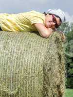 Peasant woman is lying on the hay bales