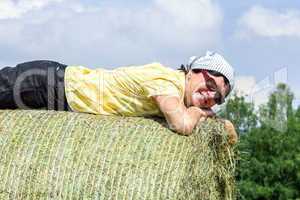 Peasant woman is lying on the hay bales