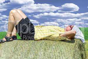 Peasant woman is lying on the hay bales