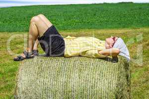 Peasant woman is lying on the hay bales