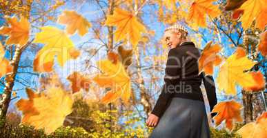 Woman and autumn leaves in the park.