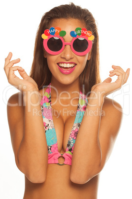 girl celebrating wearing birthday sunglasses on white