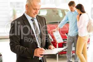 Caucasian salesman in car showroom