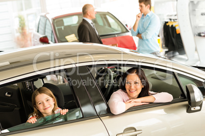 Mother and daughter trying car in dealership