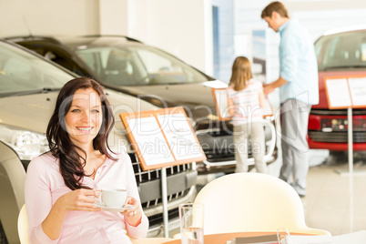 Customer drinking coffee in car dealership