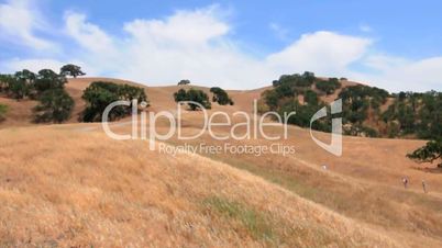 Time lapse of people walking up a hill on a windy day