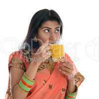 Indian woman drinking orange juice