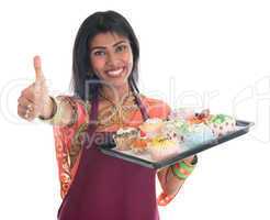 Thumb up Indian woman baking cupcakes