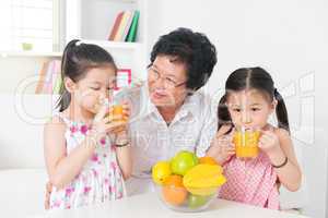 Asian children drinking orange juice
