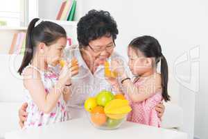 Asian family drinking fresh orange juice