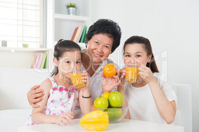 Asian family drinking orange juice.