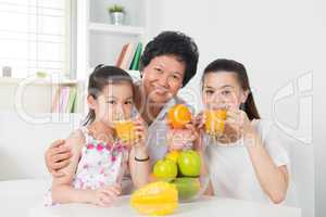 Asian family drinking orange juice.