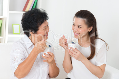 Asian women eating yogurt.