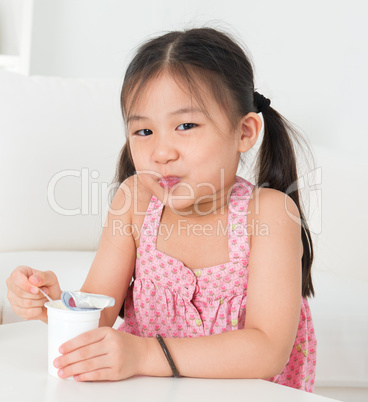 Asian kid eating yoghurt