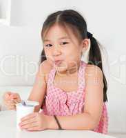 Asian kid eating yoghurt