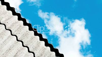 clouds rushing across the sky over the roof line of a house