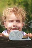 Lächelndes kleines Mädchen mit schönen lockigen blonden Haaren