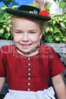 Portrait eines kleinen lachenden bayerischen Mädchen mit Hut