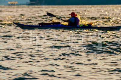 Sillouette of man kayaking on lake
