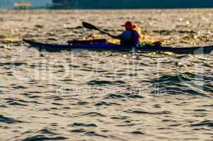 Sillouette of man kayaking on lake