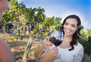 Young Woman Enjoying Glass of Wine in Vineyard With Friends