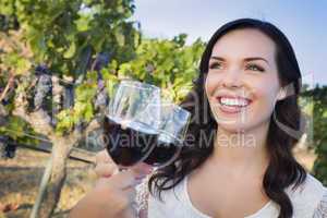 Young Woman Enjoying Glass of Wine in Vineyard With Friends