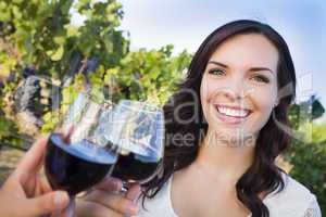 Young Woman Enjoying Glass of Wine in Vineyard With Friends