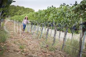 Young Female Farmer Inspecting the Grapes in Vineyard
