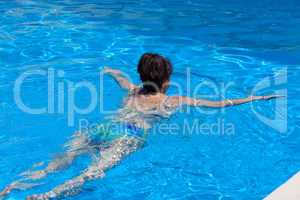 Middle-aged woman swims in the swimming pool