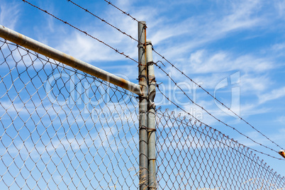 Mesh fence with barbed wire