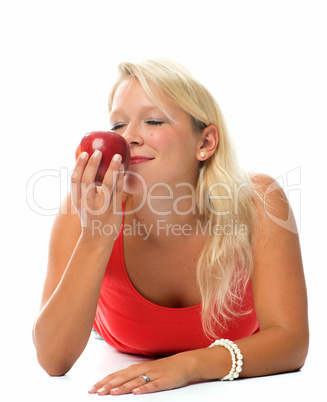 Blonde Frau riecht an einem Apfel