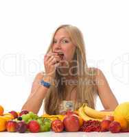 Blonde Frau beisst in einen Apfel