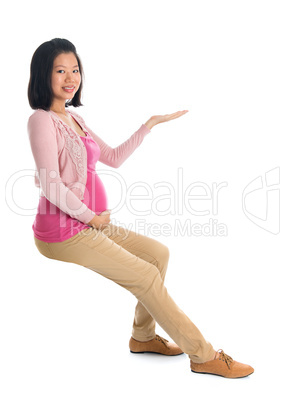 Pregnant Asian woman hand showing empty space