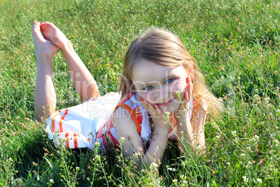 little girl lying on the grass