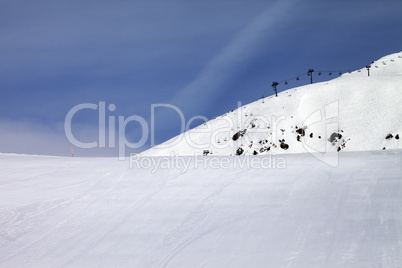 ski slope and chair-lift against blue sky