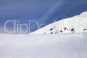 ski slope and chair-lift against blue sky