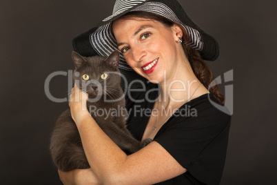Die junge Frau hält ihre Katze in den Armen