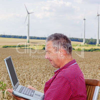 Man with laptop in cornfield