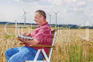 Man with laptop in cornfield