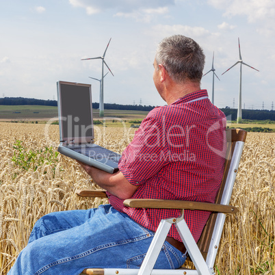 Man with laptop in cornfield