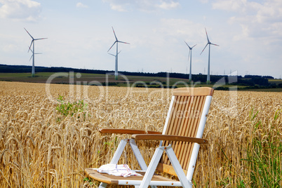Garden chair in front of the corn field with windmills
